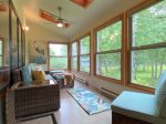 Enclosed sun room off of the living room with partial Whitefish Lake views and views of the stream  